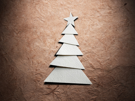 Christmas tree cut out from paper on old paper backgroundの写真素材