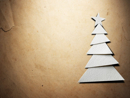 Christmas tree cut out from paper on old paper backgroundの写真素材