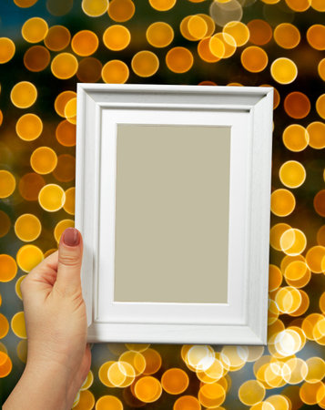 Wooden frame in beautiful woman hands on the background christmas bokeh
