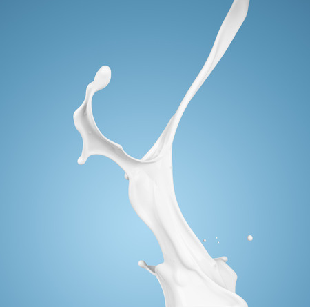 milk or white liquid splash on blue background. isolatedの写真素材