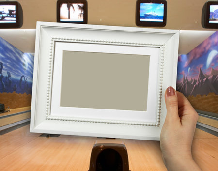 Wooden frame in beautiful woman hands on the background of bowling lanes