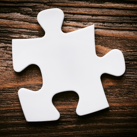 Placing missing a piece of puzzle. business concept. wooden backgroundの写真素材