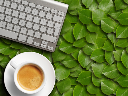 coffee mug and keyboard. background of green leavesの写真素材