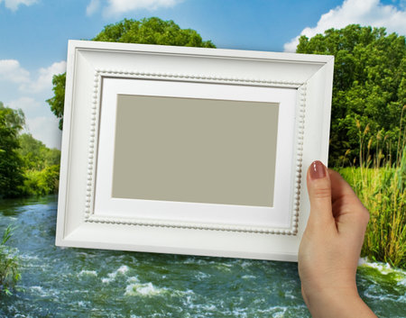 Wooden frame in beautiful woman hands on the forest background