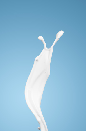 milk or white liquid splash on blue background. isolatedの写真素材