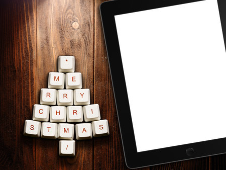 Christmas tree made of computer keys and tablet computer on wooden background . 3d rendering