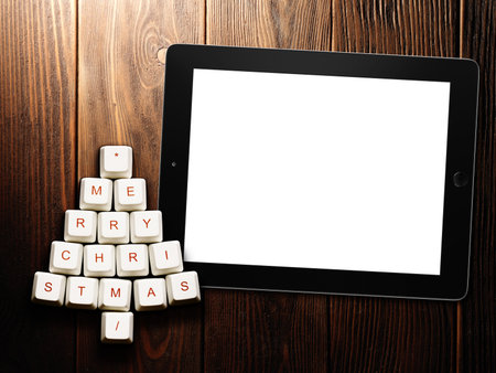 Christmas tree made of computer keys and tablet computer on wooden background . 3d rendering