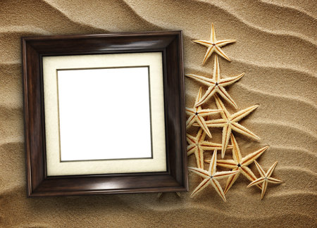 Pictue frame on shells and sand background. Copy space.