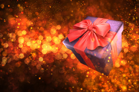 Gift box with red ribbon on golden bokeh background. 3dの写真素材