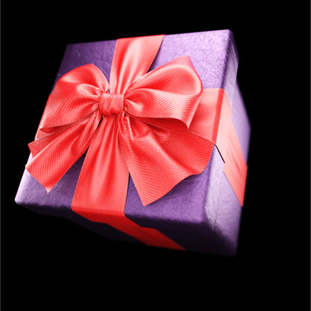 Gift box with red ribbon on black background. 3dの写真素材