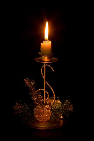 Christmas ornament and candle burning in the darkの写真素材