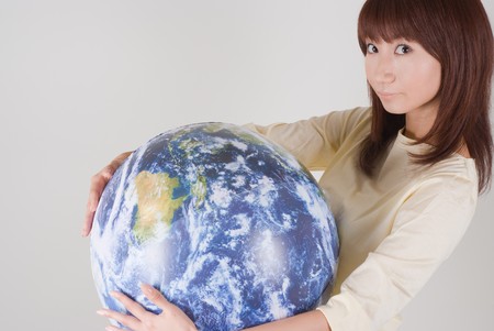 Young woman holding globeの写真素材