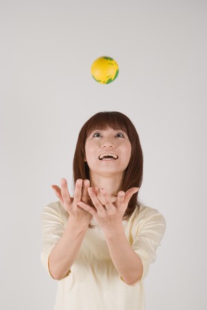 Young woman trying to catch a ballの写真素材