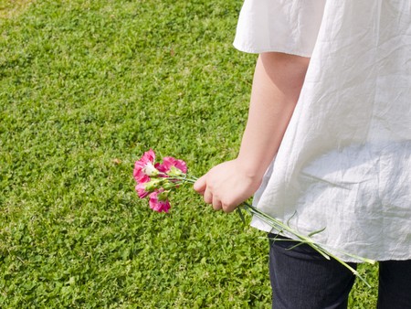 Rear view of young woman holding flowerの写真素材