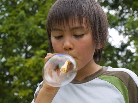 Boy playing with soap bubblesの写真素材