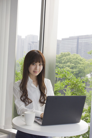 Business woman standing in front of Laptop computer in officeの写真素材