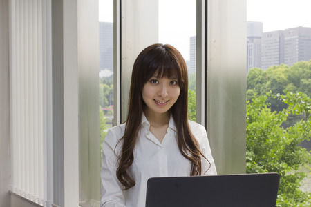 Business woman standing in front of Laptop computer in officeの写真素材