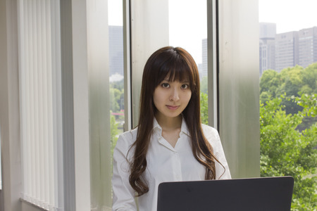 Business woman standing in front of Laptop computer in officeの写真素材