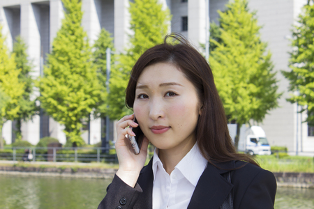 Young business woman talking with a mobile phoneの写真素材