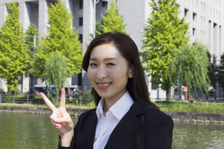 Business woman smiling with peace signの写真素材