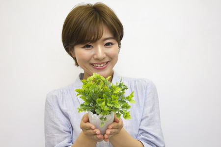 Young woman holding a plantの写真素材
