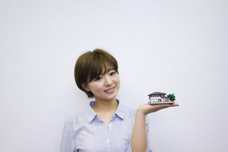 Young woman holding house modelの写真素材