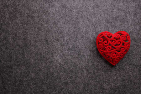Conceptual dark gray background for Valentine's Day with a red heart with free space for an inscription.の写真素材