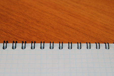 Notepad on a wooden table with copy space. View from above. Design blank