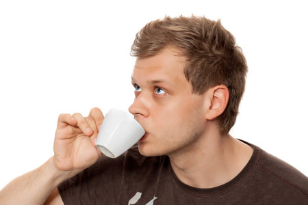 Young man drinking coffee from a coffee cup isolated on white background