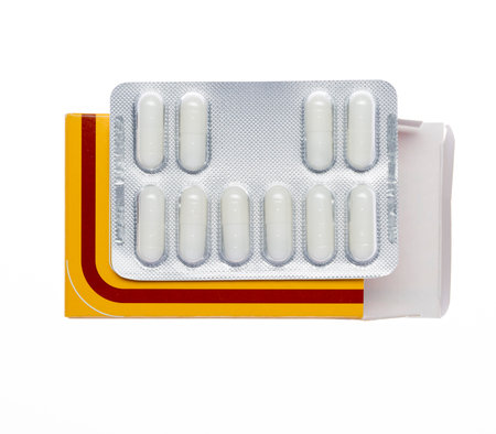 Yellow box with white pills blister pack on an isolated background