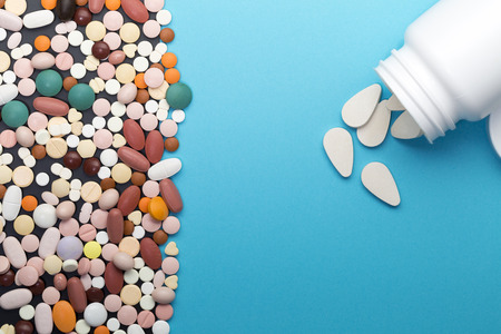 Different pills and bottle with blue color copy spaceの写真素材