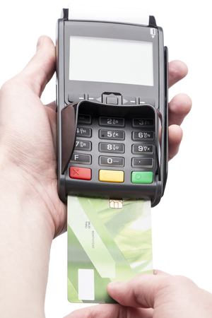 Man's hand holding a bank card on POS-terminal over whiteの写真素材