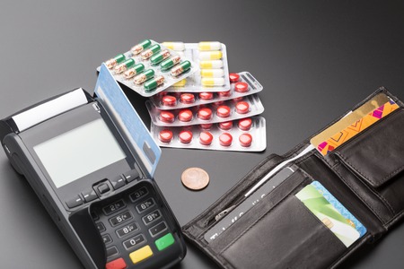 POS terminal and heap of pill blister packs over blackの写真素材