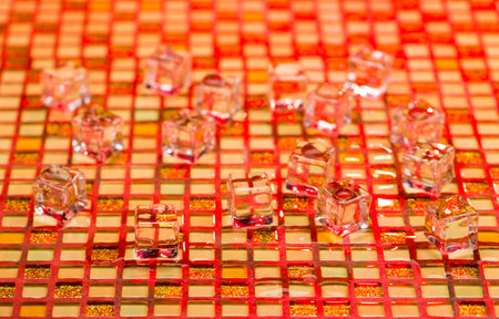 Cold and wet ice cubes on colorful glitter background