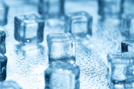 Many blue melting ice cubes on glassの写真素材