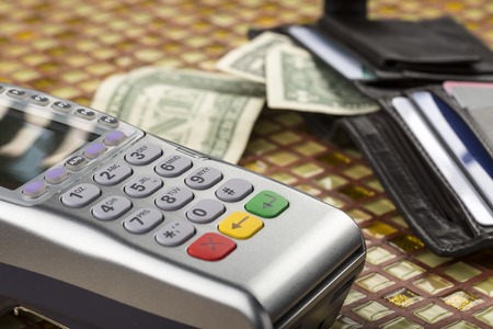 Payment wireless terminal and wallet with banknotes on modern tableの写真素材