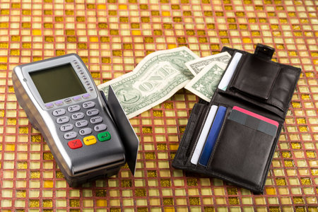Payment wireless terminal and wallet with banknotes on modern table
