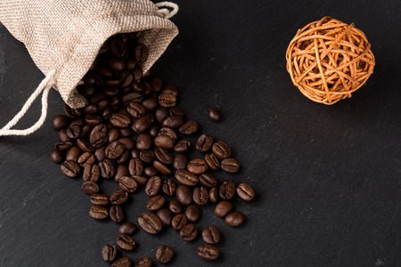 Heap coffe beans and cup of fresh coffee on dark backgroundの写真素材