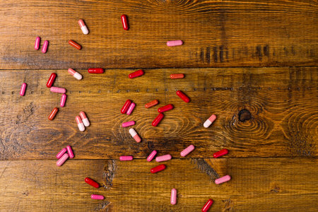 Heap of colorful drugs and pills on dark wood background
