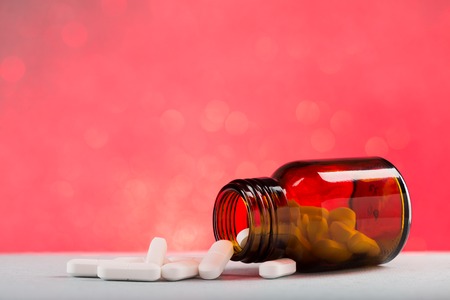 Glass pill bottle and white pillsの写真素材