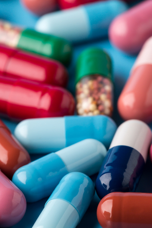 Colorful different medicine capsules on blue backgroundの写真素材