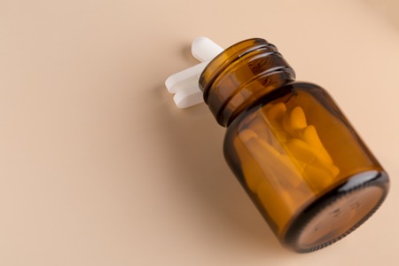 Brown glass pill bottle and white pillsの写真素材