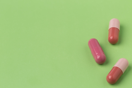 Various brown pills on green color backgroundの写真素材