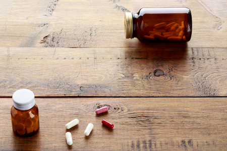 Medical bottles with white pills on a wooden backgroundの写真素材