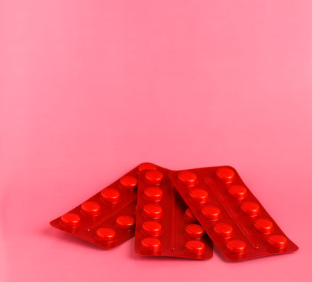 Three red blister packs of white pills