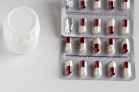 Pills blister packs and white pills bottle on white background
