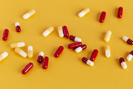 Scattered yellow and red drug capsules with active microgranulesの写真素材