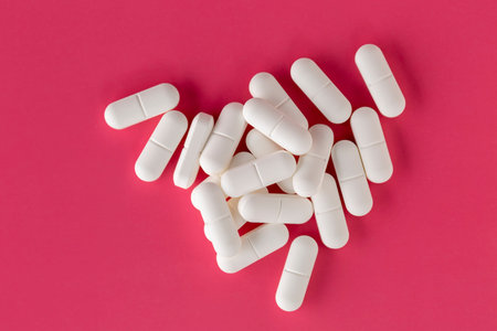 White pills pillows scattered on a red background
