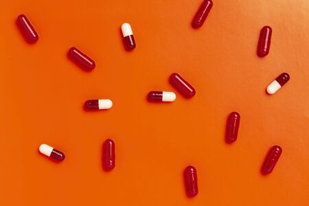 Colorful medicine capsules on a single color backgroundの写真素材
