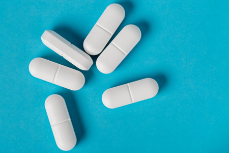 White pills on blue backgroundの写真素材